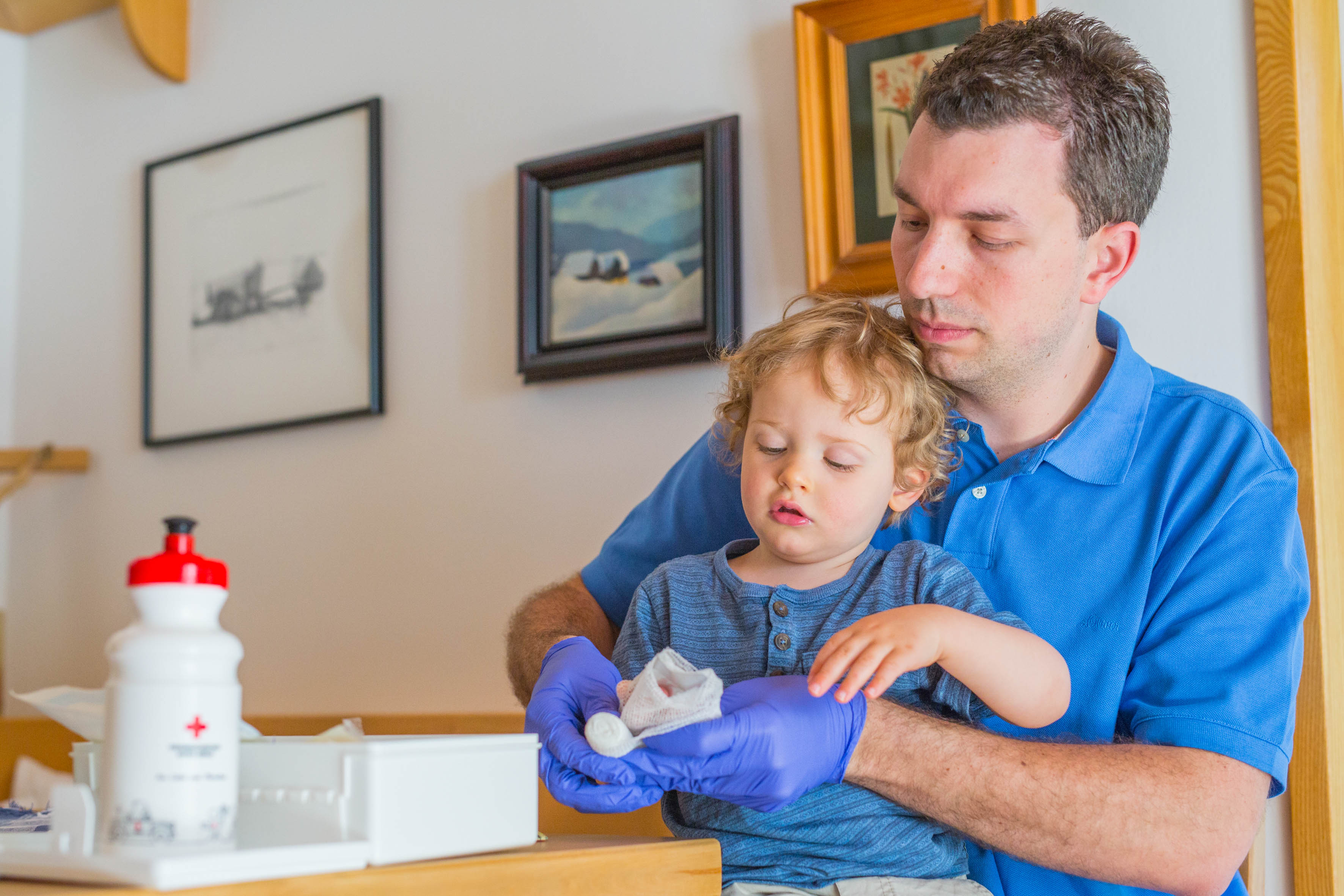 Erste Hilfe bei Kindernotfällen. Mann zeigt dem Kind einen Verband