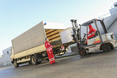 Mit Hilfe eines Staplers werden Paletten in einen LKW verladen.