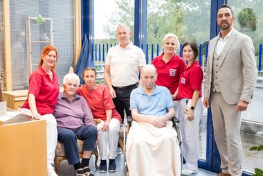 Gruppenfoto zweier Bewohner:innen mit Mitarbeitern des Seniorenwohnhauses Hallwang