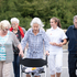 Eine Gruppe Senior_innen wird von einer freiwilligen Rotkreuz-Mitarbeiterin begleitet.