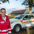 Robert Strauss - Offizier vom Dienst - steht in Rotkreuz-Einsatzuniform vor einem Kommandofahrzeug.