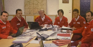 Das Bezirksretuungskommando Waidhofen/Thaya im Stabsraum rund um den Tisch mit vielen Unterlagen.