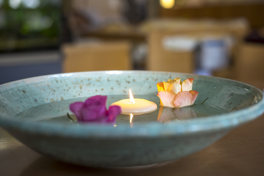 Wasserschale mit Blumen und Kerze