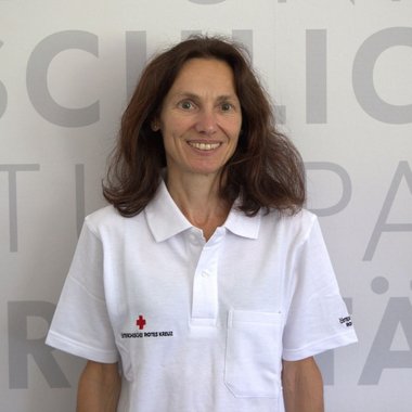 BRIGITTE PUNTAJER im Portraitfoto und mit Rotkreuz Poloshirt