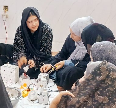 Eine Gruppe Frauen arbeitet mit Elektronikteilen