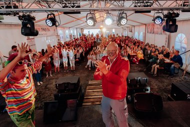 Zauberclown Manuela, Bert Neuhofer (Vizepräsident, Rotes Kreuz Salzburg), im Hintergrund alle Teilnehmer:innen, Betreuer:innen, Helfer:innen und Ehrengäste des Landesjugendcamps