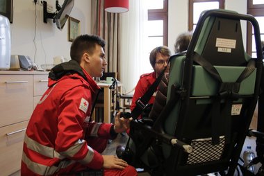 Zwei Rettungssanitäter holen eine Dame aus dem Seniorenzentrum zum Transport ins Krankenhaus ab.