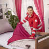 Ein Mitarbeiter des Roten Kreuzes bereitet ein Pflegebett vor