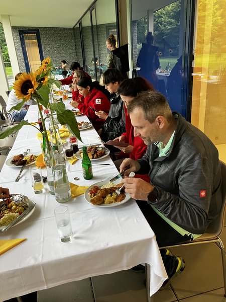 Mitarbeiter:innen des Seniorenwohnhauses Hallein sitzen gemeinsam an einem Tisch und essen