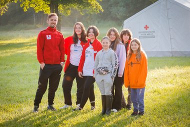 Gruppenfoto von Jugendrotkreuz-Kindern vor einem Zelt.