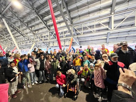 Eine Gruppe von Kindern mit Begleitpersonen steht im Stadio des FC Red Bull Salzburg und winkt in die Kamera.
