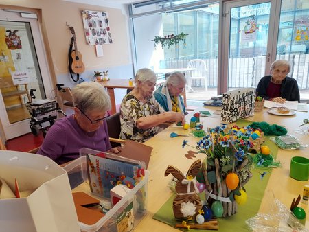 Bewohner:innen und Besucher:innen dekorieren gemeinsam Ostereier