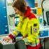 Eine Sanitäterin beim Fahrzeugcheck in der neuen gelbroten Uniform.