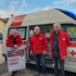 3 freiwillige Rotkreuz-Markt-Fahrer vor dem Transportfahrzeug