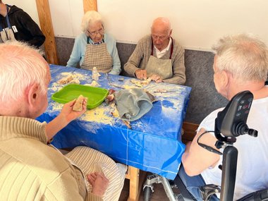 Ältere Menschen formen Specksteine zu Figuren