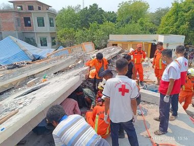 © Myanmar Red Cross Society Mitarbeiter:innen des Roten Kreuzes suchen in den Trümmern eines Wohnhauses nach Überlebenden