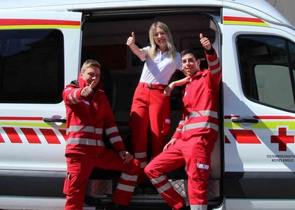 Ehrenamtlich, die einen Daumen nach oben aus einem Rettungswagen geben