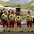 Man sieht Sanitäter:innen von hinten. Sie stehen erhöht und überblicken einen Teil des Red Bull Rings. Es sind auch einige Motorsportfans im Bild.