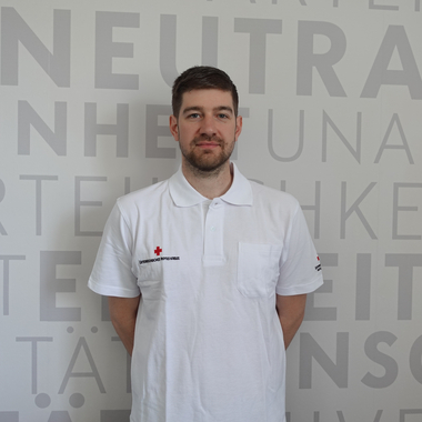 Philipp Wallner - © Rotes Kreuz Tirol Christine Widmann Philipp Wallner im Rot Kreuz Shirt vor der Grundsätzewand im Portrait