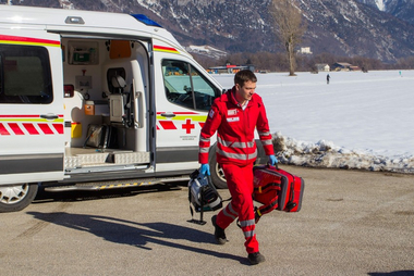 Ein Rotkreuz Sanitäter kommt am Unfallort an. In seiner Hand befindet sich ein Notfallrucksack