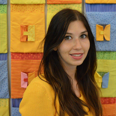 Carina Kirschner - © Rotes Kreuz Tirol Denise Baumgartner Carina Kirschner vom Kinderbetreuungszentrum Seifenblase im Portrait vor einer bunten Wand