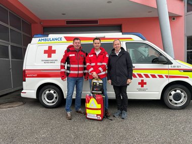 von links Markus Moser (Bezirksrettungskommandant Radstadt), Christian Daller (First Responder) und Thomas Oberreiter (Bürgermeister Flachau). Im Hintergrund ist ein Rettungswagen zu sehen.