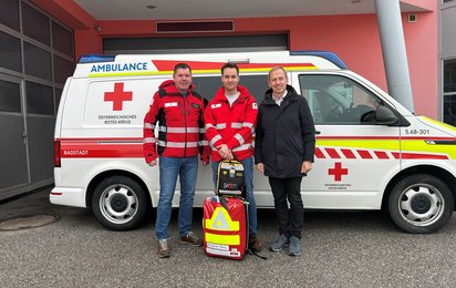 von links Markus Moser (Bezirksrettungskommandant Radstadt), Christian Daller (First Responder) und Thomas Oberreiter (Bürgermeister Flachau). Im Hintergrund ist ein Rettungswagen zu sehen.