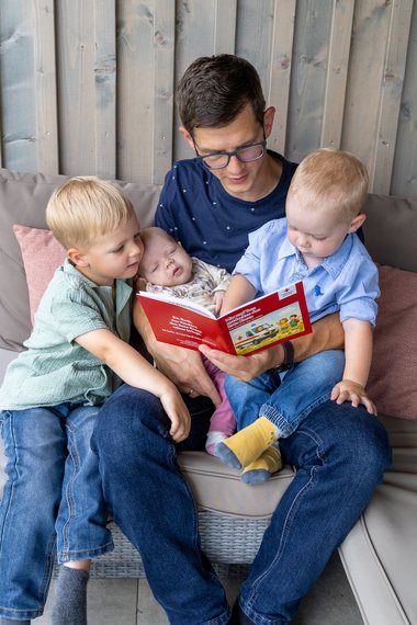 Günther Enzenhofer mit seinen drei Kindern beim Vorlesen