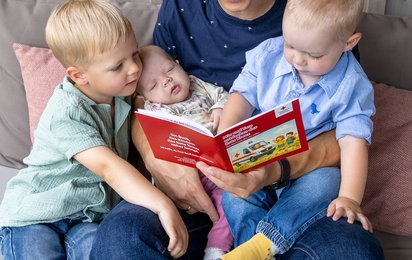 Günther Enzenhofer mit seinen drei Kindern beim Vorlesen