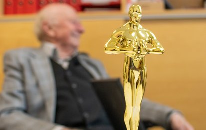 Lese-Opi_News - © Rotes Kreuz Graz-Stadt / S. Weiß Eine Oscar-Statuette mit Walter Planer im Hintergrund