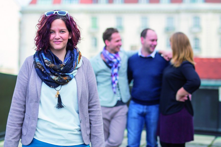 Verwaltung Management - © Österreichisches Rotes Kreuz, Thomas Holly Kellner eine weibliche Person steht im Vordergrund. Im Hintergrund erkennt man drei weitere Personen verschwommen, die miteinander reden