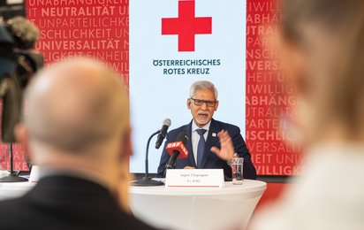 IFRC Generalsekretär Jagan Chapagain vor Rotkreuzlogo
