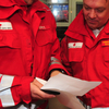 Finanz und Ressourcenoptimierung - © Österreichisches Rotes Kreuz Armin Fauland zwei Rotkreuz Mitarbeiter stehen beisammen und studieren eine Unterlage. Es sind zwei Männer