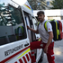 Nico Fritz - Zivildienstleistender im Rettungs- und Krankentransportdienst hat einen Notfallrucksack am Rücken und steigt gerade in einen Rettungswagen ein. Er lächelt dabei in die Kamera.