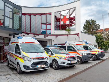 vier Einsatzfahrzeuge (RTW, Einsatzleiter, Notarztwagen und KTW) stehen aufgereiht vor dem Gebäude der Bezirksstelle Osttirol