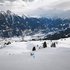 Panoramaaufnahme des Skigebiets in Bad Hofgastein. Im Vordergrund ist ein Rennkurs ausgesteckt, der von einem Skifahrer befahren wird. Im Hintergrund sind Berge und ein bewölkter Himmel zu sehen.