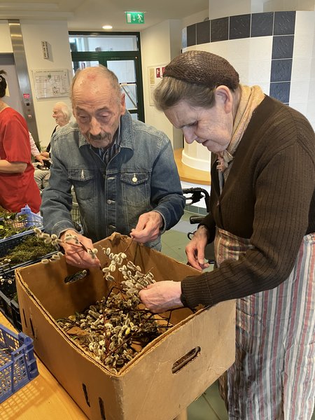 Zwei Bewohner:innen beim Aussuchen der schönsten Palmwedel 