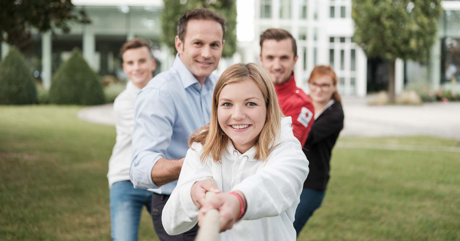 Unternehmenskooperationen - © (c) www.robertmaybach.com Fünf Menschen ziehen gemeinsam an einem Seil.