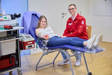 Eine junge Frau spendet Blut.