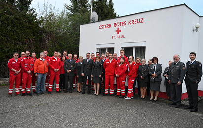 Gruppenfoto von mehreren Personen in Rotkreuz-Uniform vor einem Rotkreuz-Gebäude