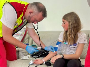 Ein Sanitäter misst den Blutdruck einer Patientin