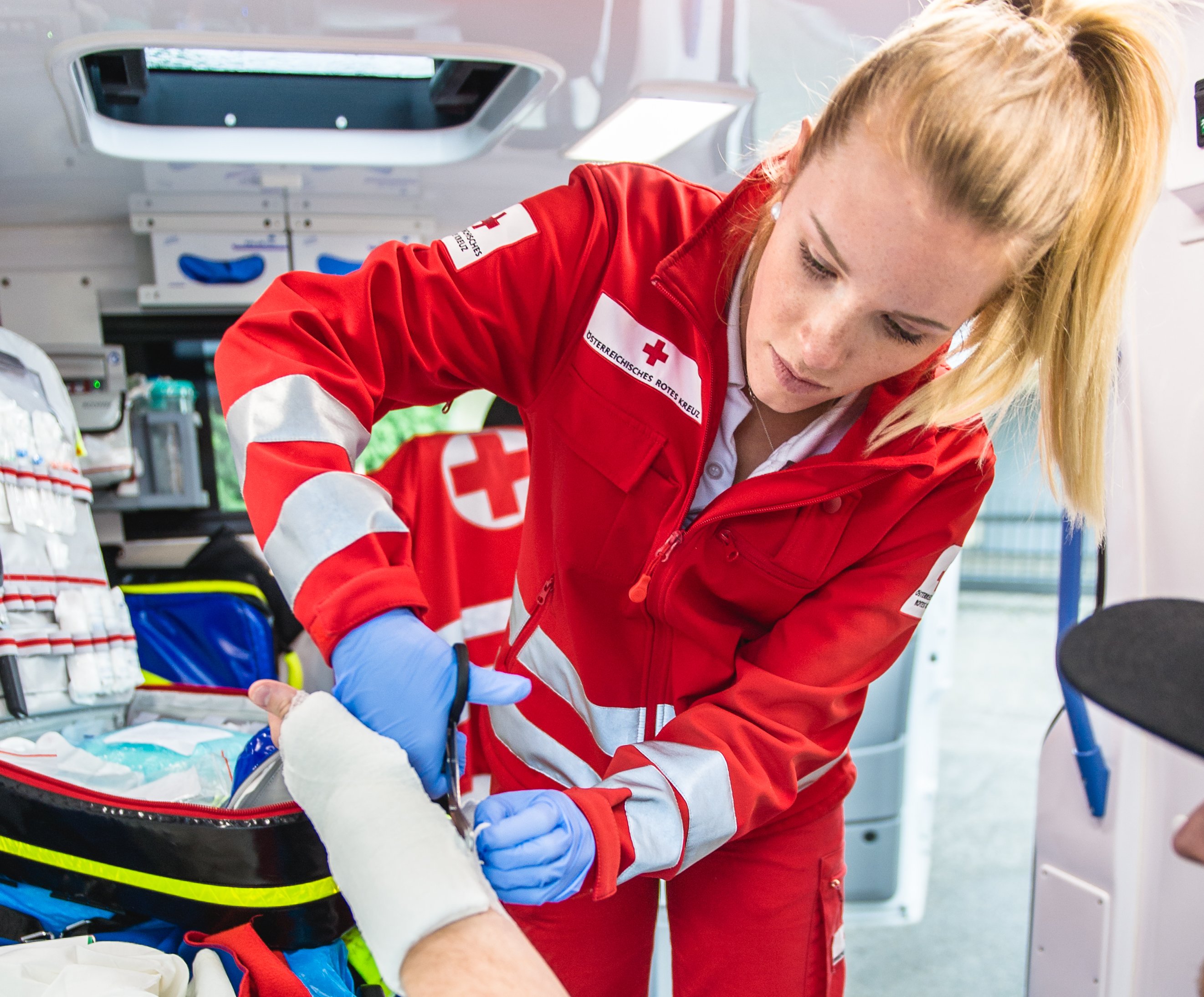 Sanitäterin verbindet Unterarm eines Patienten