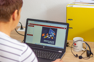 Frau sitzt vor dem Laptop und betrachtet die Einstiegsseite zum Online-Kurs