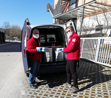 2 Essen auf Rädern-Mitarbeiter:innen vor dem Essen auf Rädern-Auto