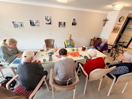Bewohnerinnen des Seniorenwohnhauses helfen bei der Gestaltung der Wände mit.