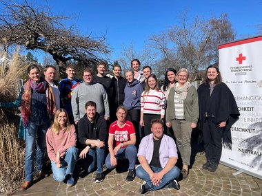 Gruppenfoto der Teilnehmerinnen der Erste-Hilfe-Lehrbeauftragenausbildung des Jugendrotkreuzes Salzburg. Das Foto wurde im Freien bei Sonnenschein aufgenommen.