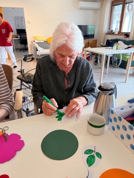 Bewohnerinnen des Seniorenwohnhauses helfen bei der Gestaltung der Wände mit.