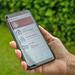 Eine Frau hält ein Smartphone mit dem Startbild der Team Österreich-App in ihrer Hand