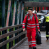 Rotkreuz-Mitarbeiter in Uniform geht über eine Brücke.