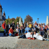 Eine Gruppe von Leuten sitzen im freien neben einer kleinen Kirche